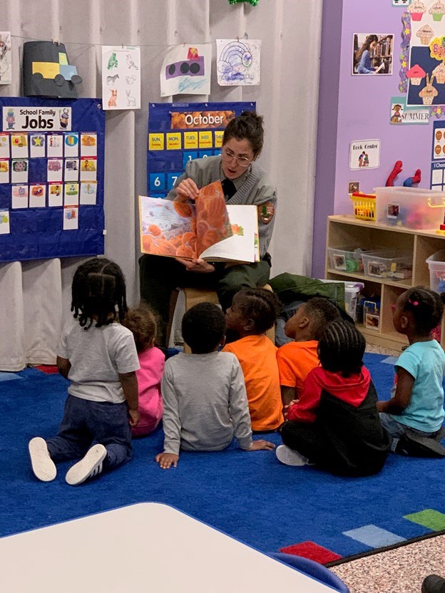 A ranger reads to children in a classroom.