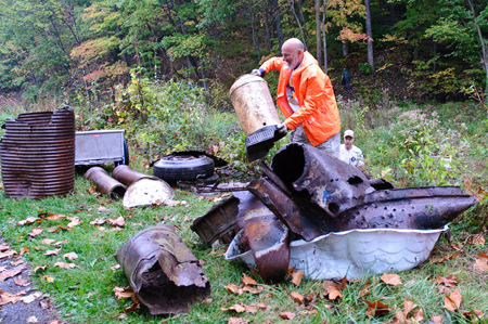 Volunteers clean up items left at an old dump site on River Day.