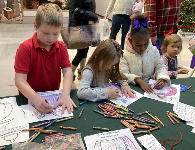 Four kids coloring at a table.