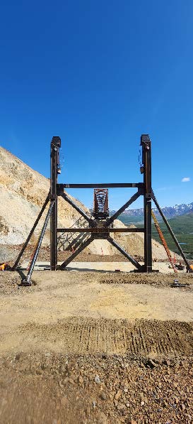 Several anchored beams on the west side of the slide.Through the beams, the main bridge truss can be seen on the opposite side of the slide.
