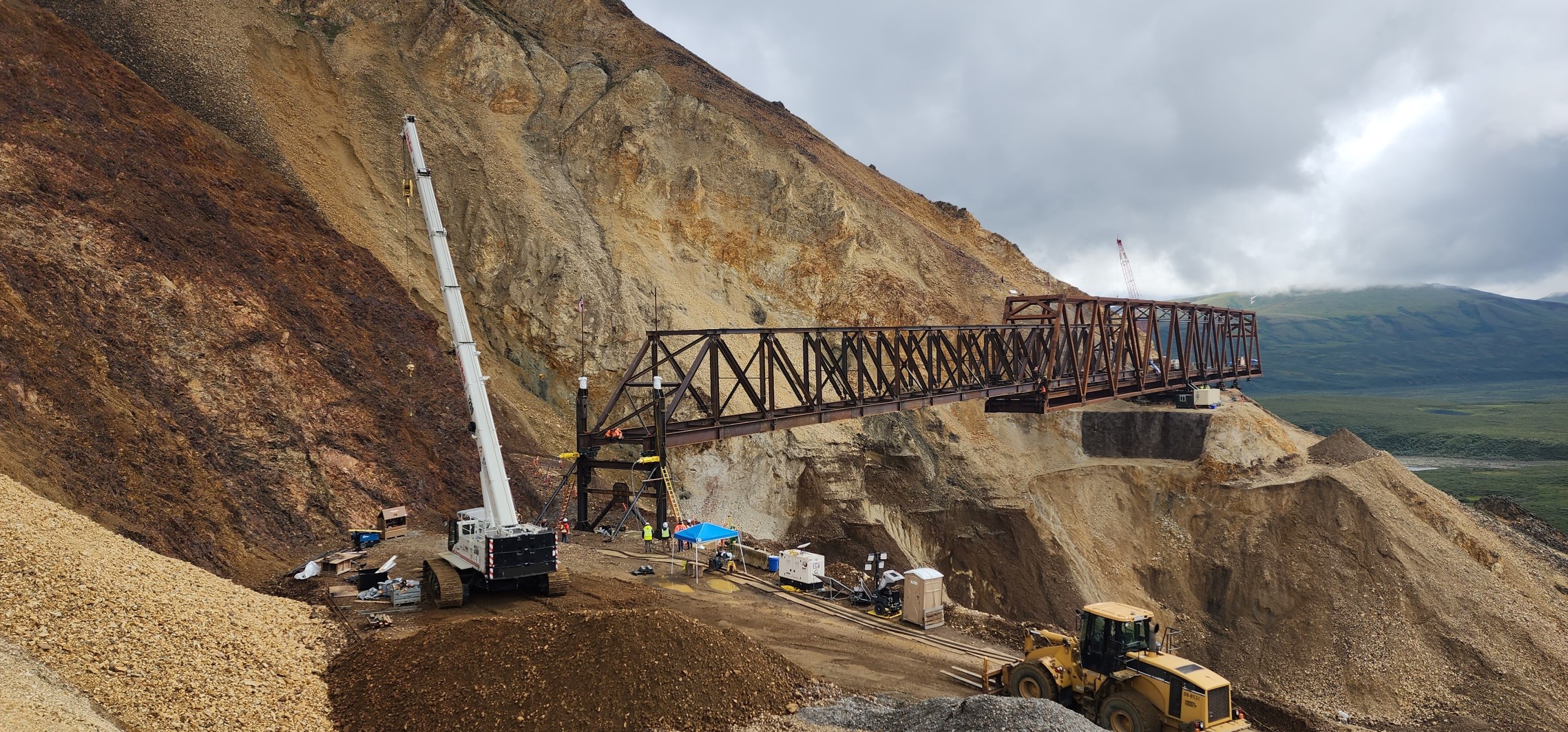 View from the west side of the launch truss fully spanning the landslide, and the main bridge truss staged on the east side of the slide.