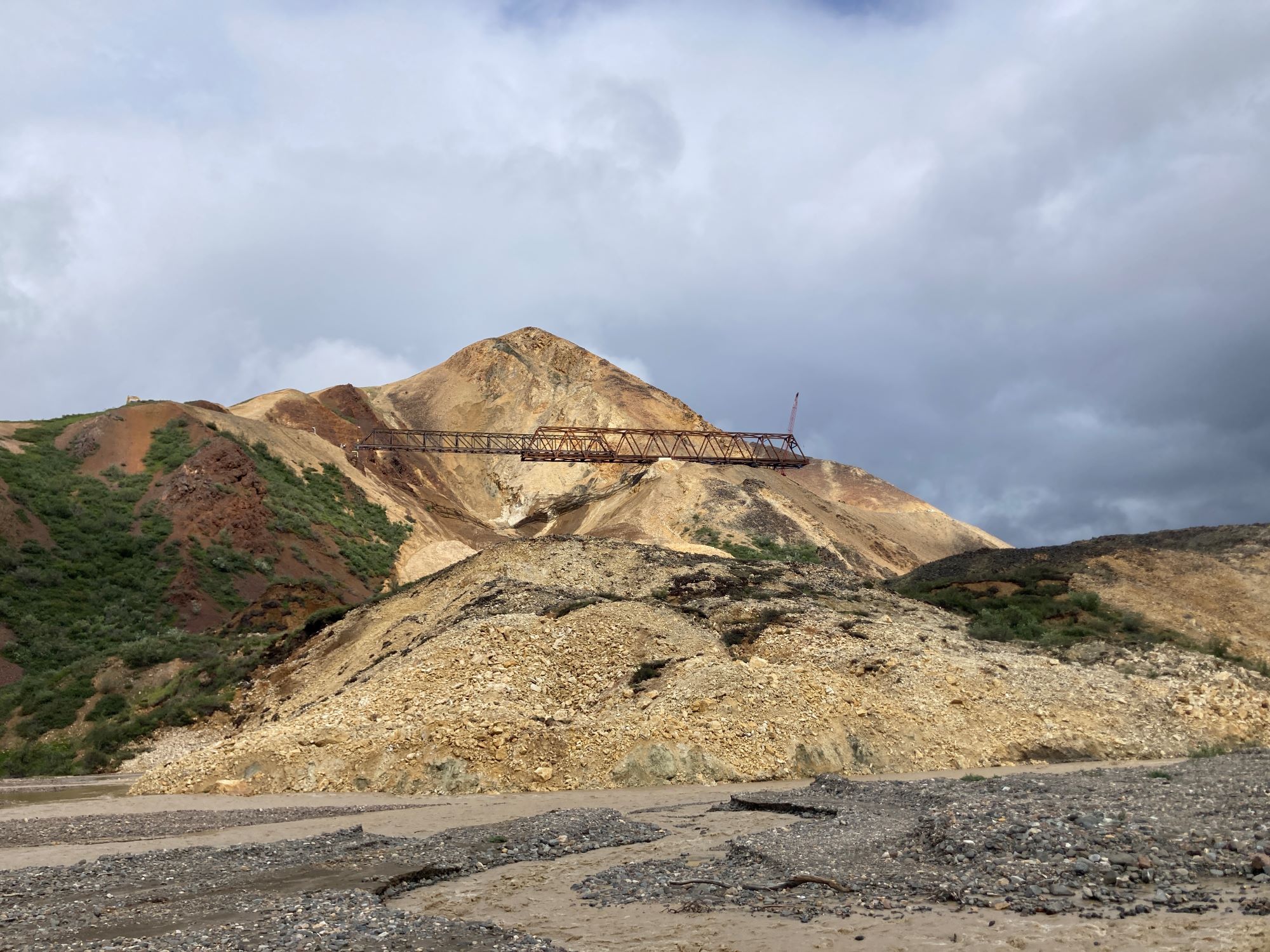 View from the river valley below the landslide, loooking up at the bridge. The launch truss spans the slide and is attached to the west receiving tower.