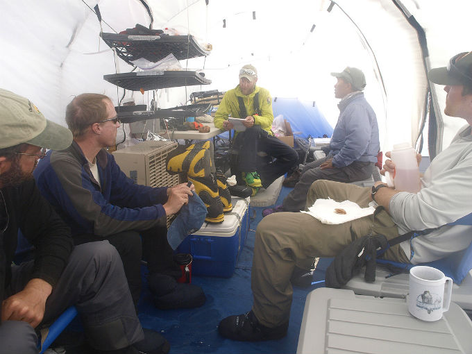Five rangers and volunteers sitting and talking in a tent