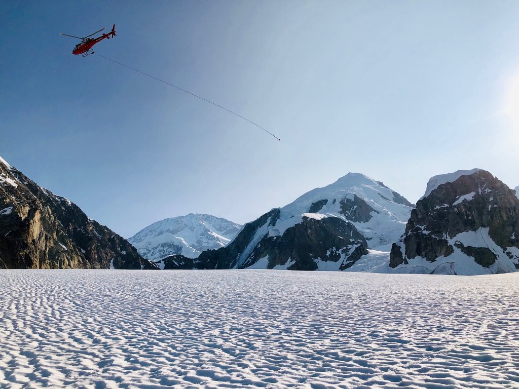 Helicopter with a long, empty rope trailing in the wind as it flies off
