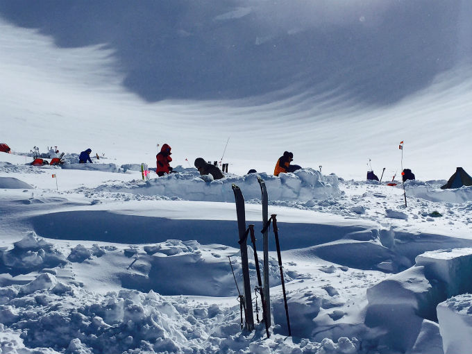 Snowy, windswept camp with bundled up climbers