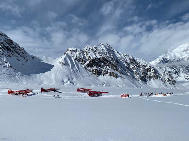 Four Otter aircraft sit on the glacier runway