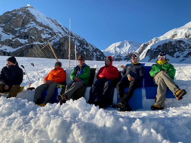 Six mountaineers kick back on a snow couch