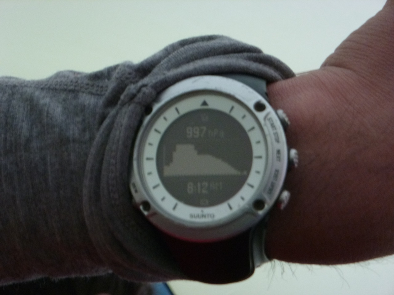 A watch face depicts dropping barometric pressure as a storm rolls in