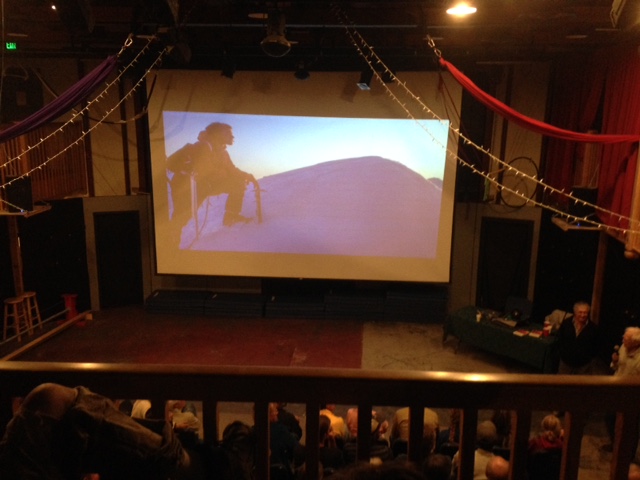 Theater screen depicting a slide of climber near the summit of Mount Huntington