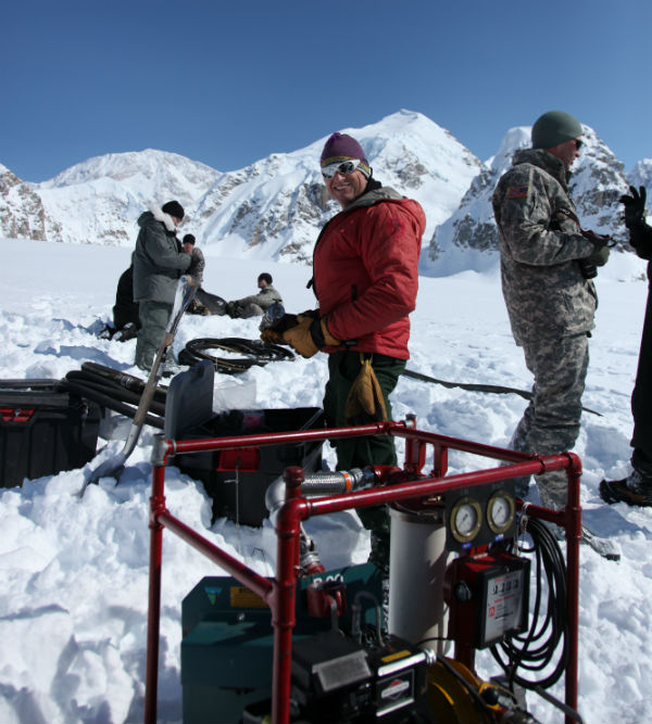 Ranger and military personnell on glacier setting up fueling equipment