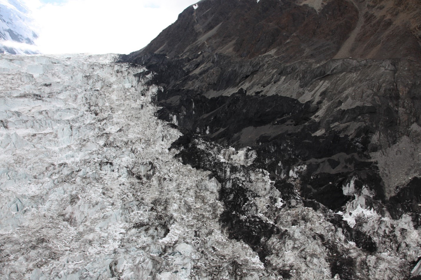 Closeup of interface between jumbled glacier icefall and the steep side ridge