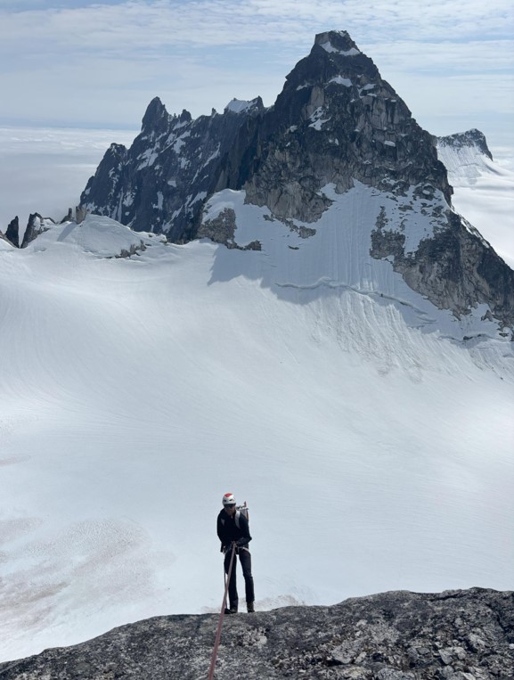 A ranger stands facing a mountain peak