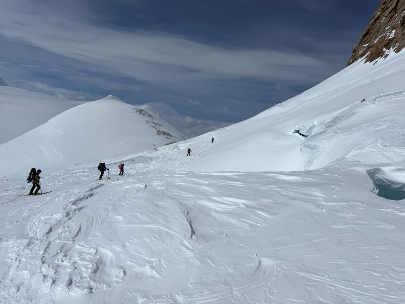 Five rangers skiing up a snowy hill 