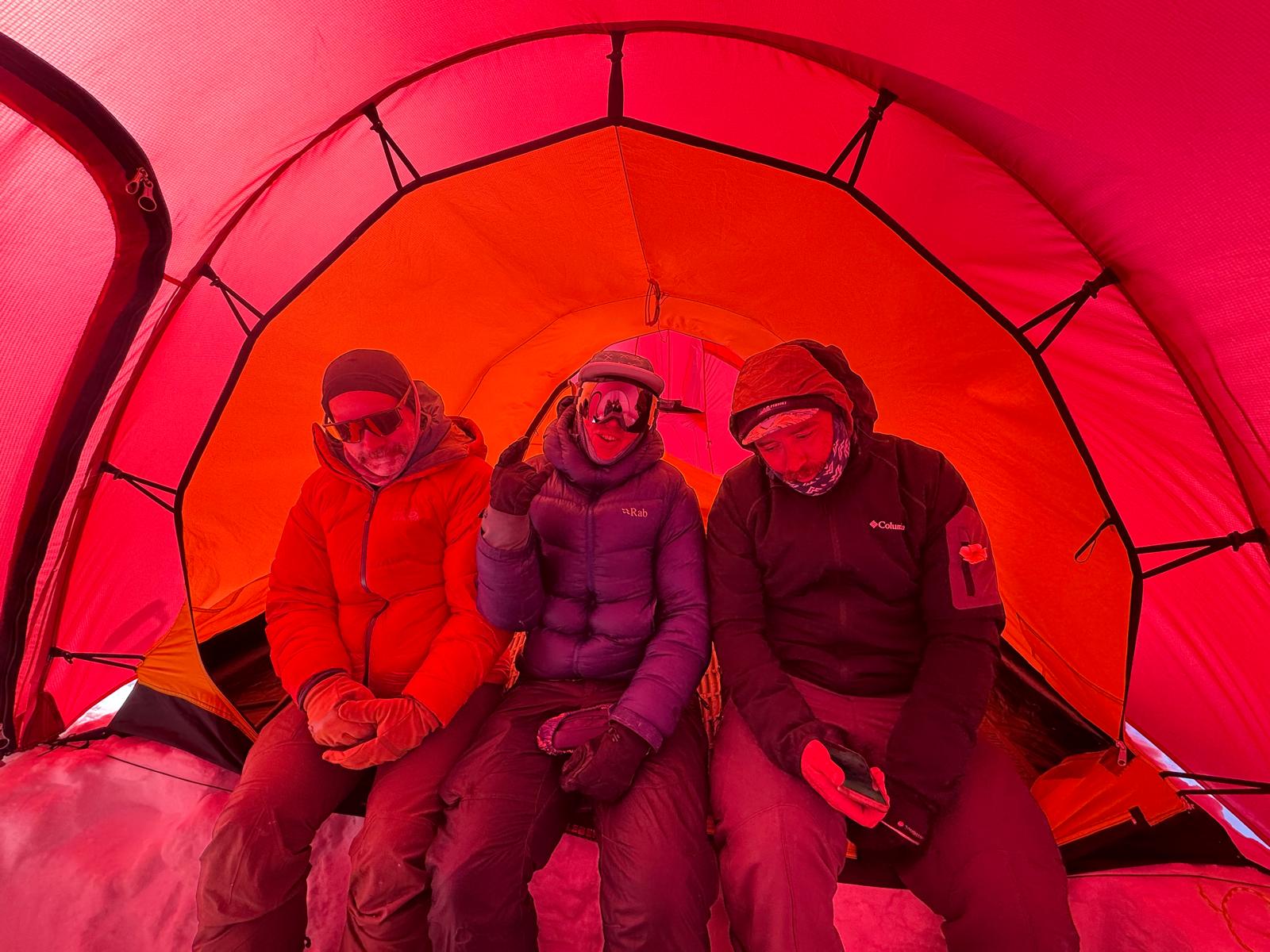 3 rangers sitting in a red tent in full winter gear