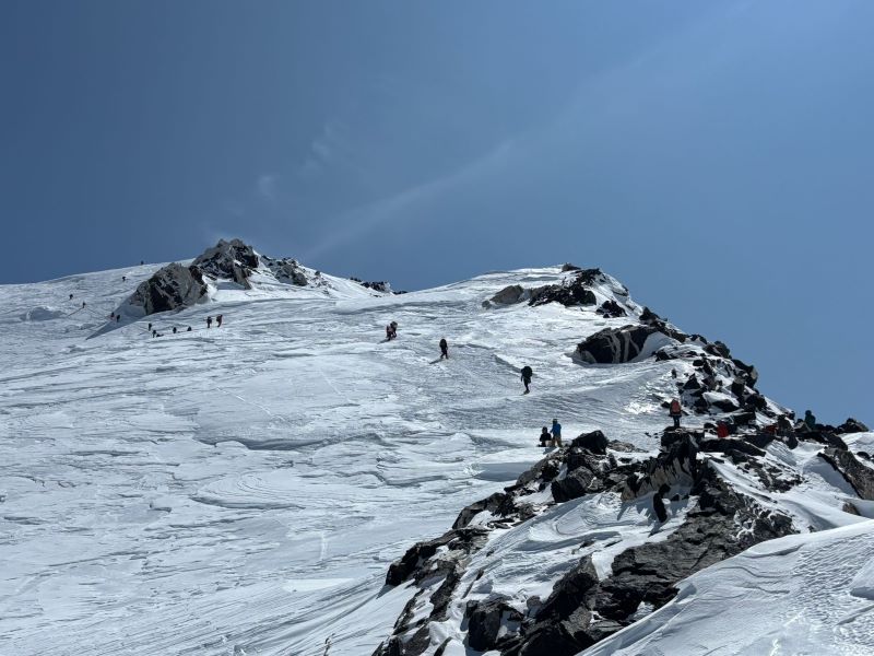 a line of mountaineering rangers climbing near a ridge