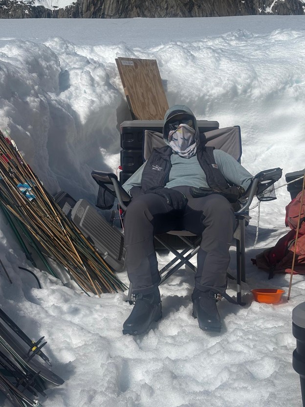 A ranger sits in a chair wearing UV protection gear