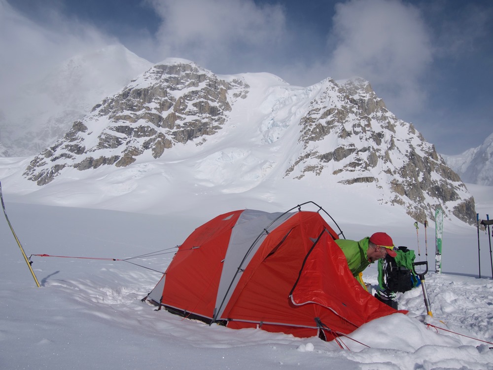 Ranger emerging from tent on a glacier