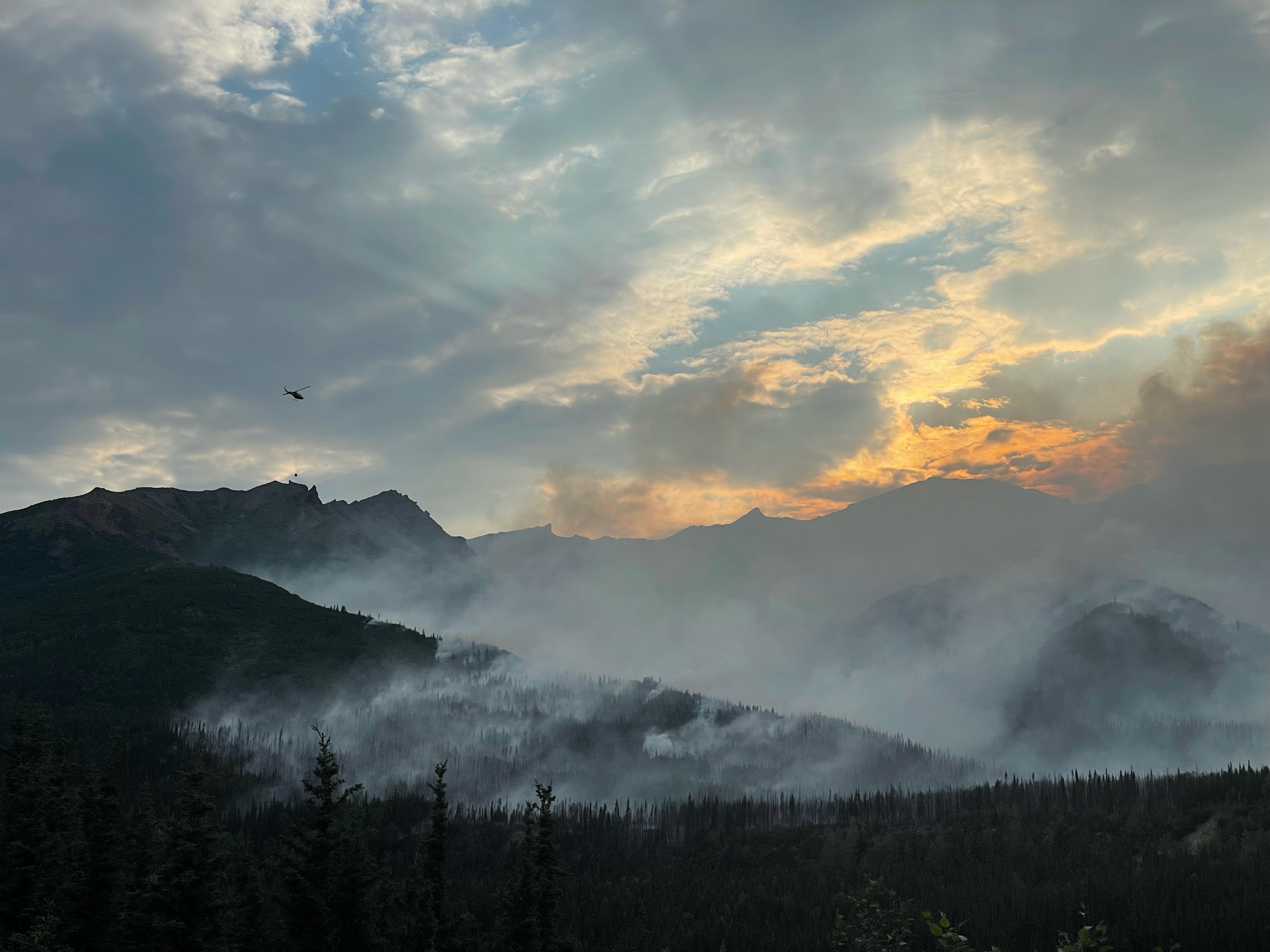 Wildfire smoke rises from mountains