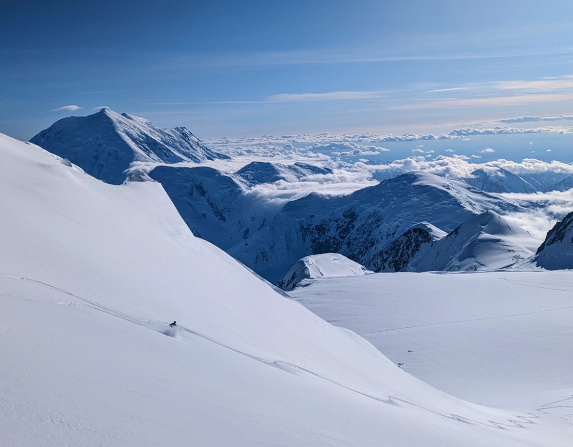 View of a skier descending a snowy mountain slope