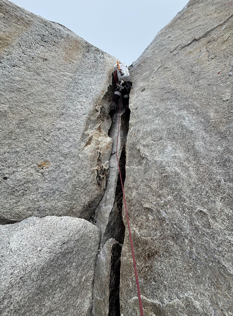 A ranger climbs up a rock face
