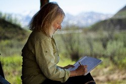 Author Kathleen Dean Moore writes on the porch of the East Fork Cabin