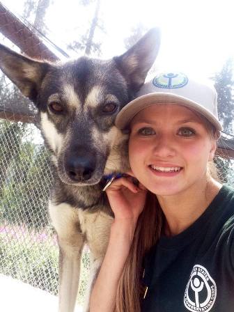 Youth Conservation Corps volunteer poses with sled dog 