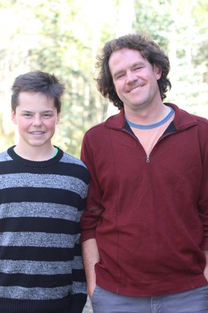 Man and teenage boy posing together for a photo