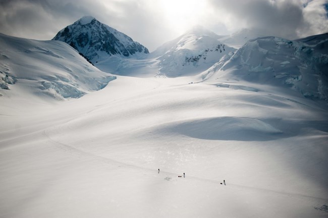three people skiing across a huge glacier in the Alaska Range