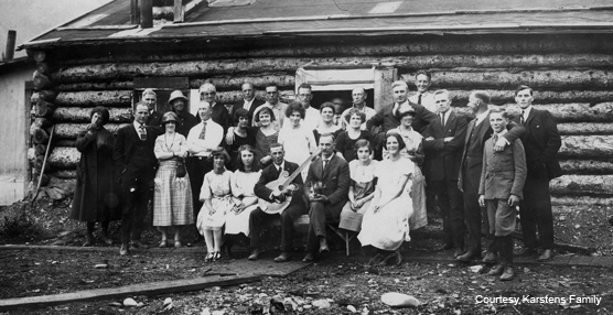 Historic photo of people in front of a cabin