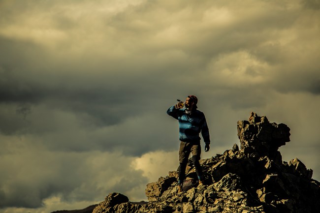 a man standing on a rocky outcropping atop a mountain