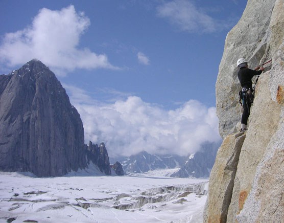 a person rock climbing above a vast glacier