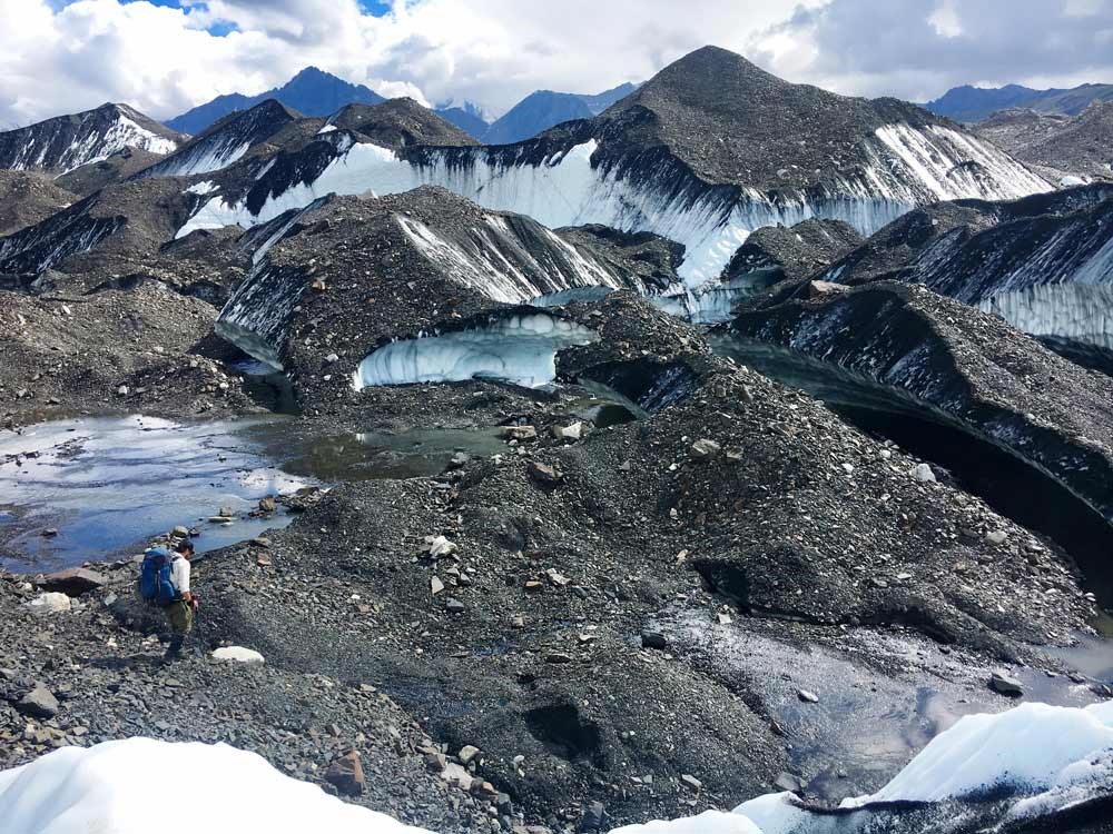 a glacial moraine covered in gravel, with patches of blue ice exposed