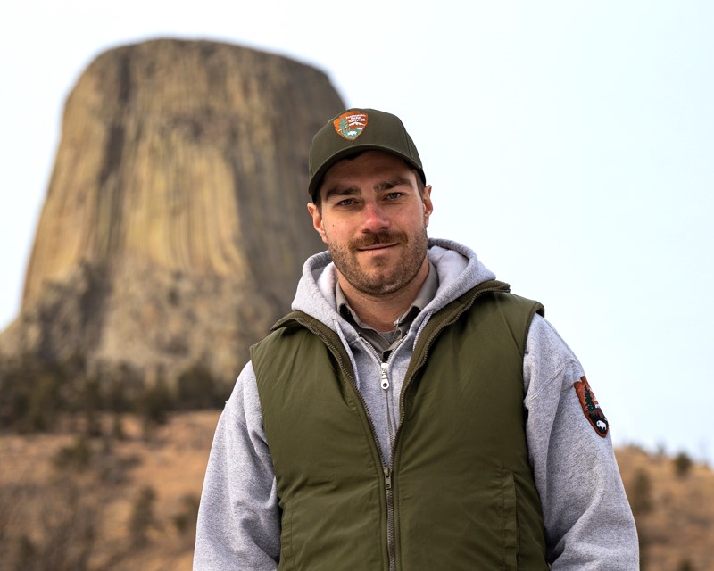 Park Ranger with hat on devils tower in background