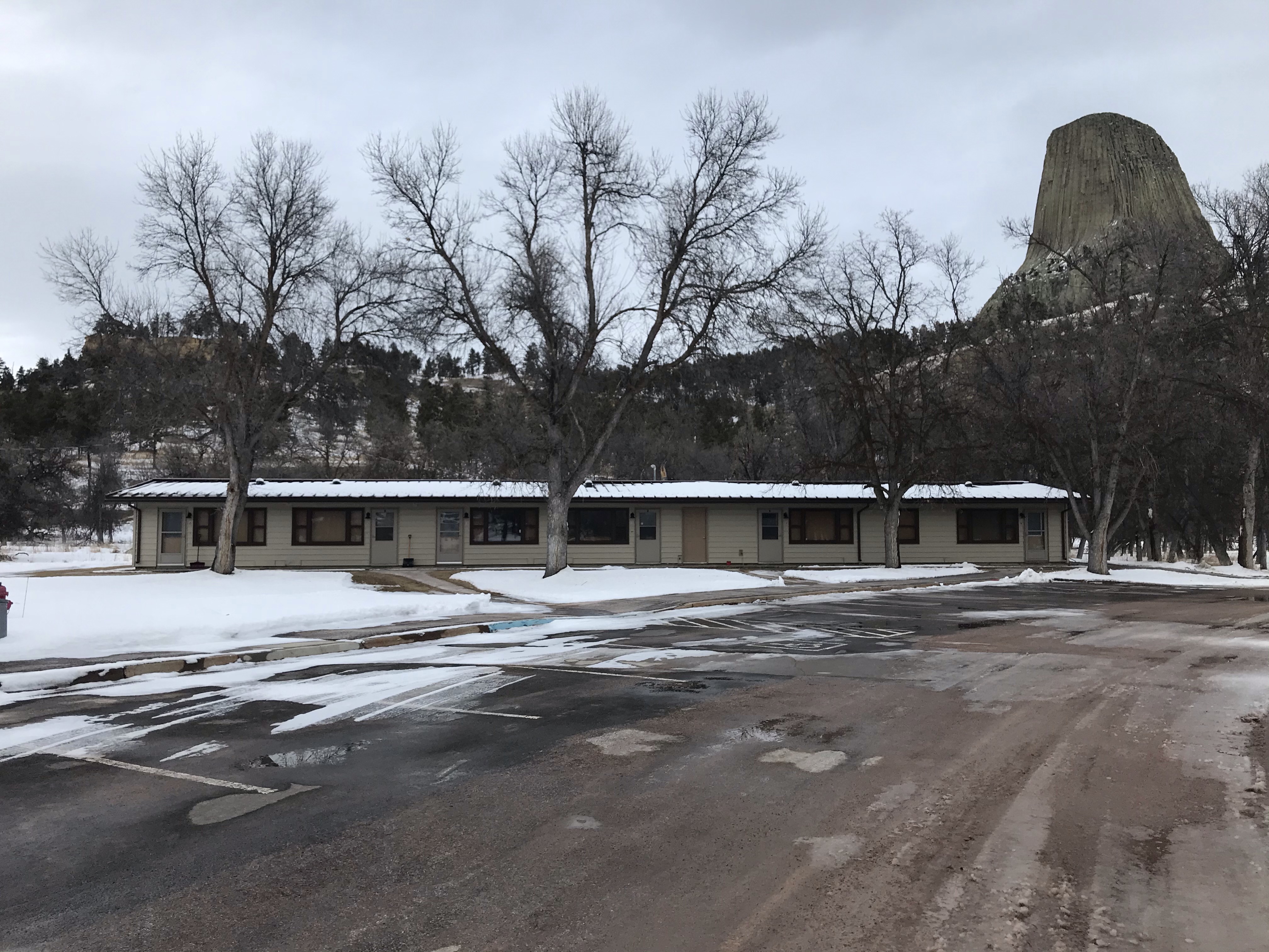 Single level apartment complex with large rock monolith in the background.