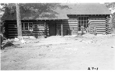 An almost-finished log structure, with several workers out front