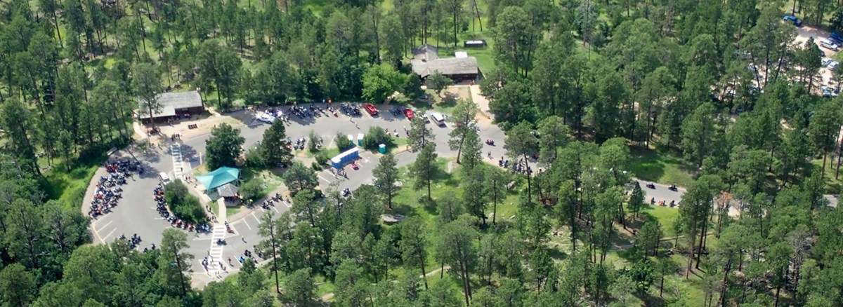 aerial view of visitor center parking lot with cars and people