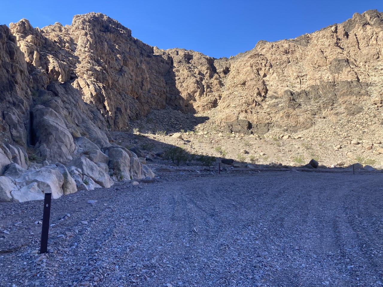 A gravel road in the foreground, a rocky ridge in the background.