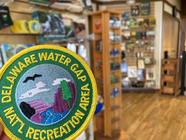 A circle Delaware Water Gap NRA patch with other bookstore items in the background.
