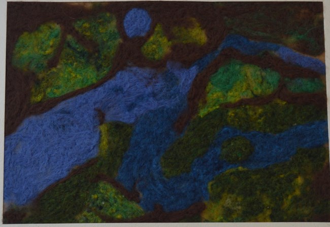 A wool pinned piece of art representing the Delaware River and surrounding landscape.