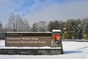 The entrance sign to Delaware Water Gap NRA in winter with snow on the ground.