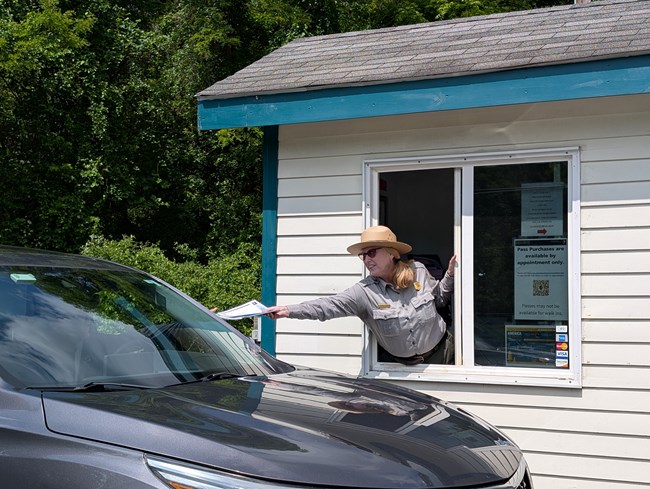 A fee ranger working at a fee booth.