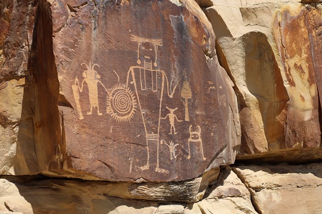 Human-like figures pecked into a rock face