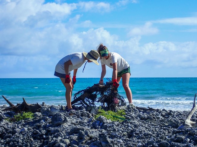 two volunteers cleaning marine debris