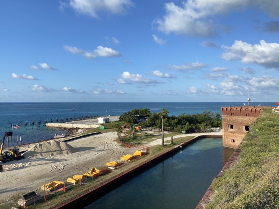 View of construction area adjacent to campground and moat from atop the brick fort with view of ocean beyond