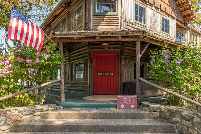 Front door of old log inn with American Flag.