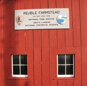 White NPS sign on red barn.