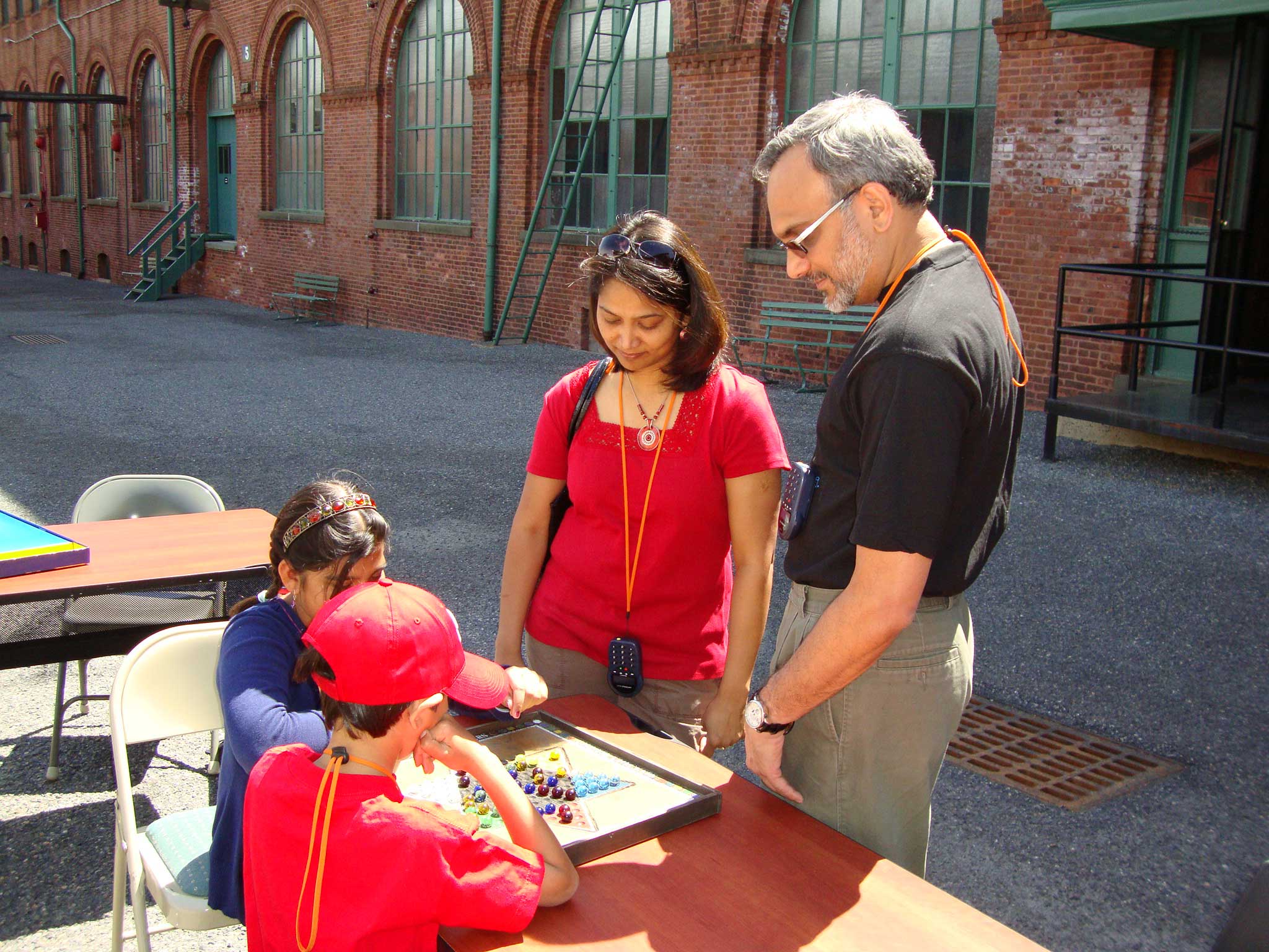 A family learns to play an Edison family game, Chinese Checkers.
