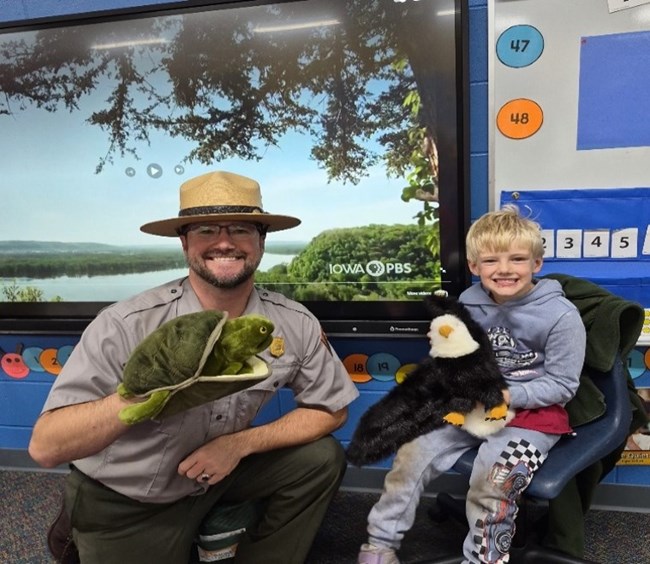 Image of a park ranger and child with puppets