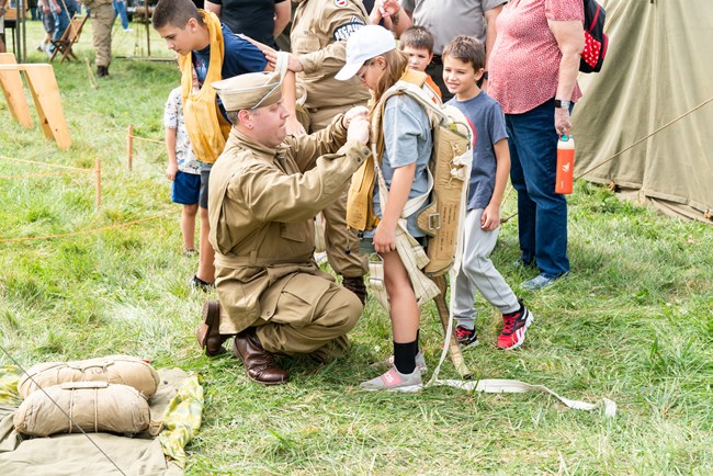 A living history reenactor dressed kids up in U.S. paratrooper gear