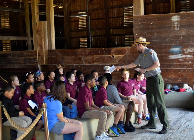 A park ranger speaks to a group of students
